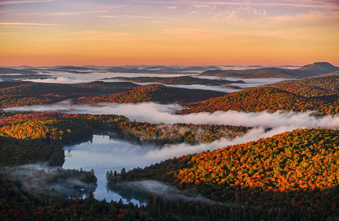 Sunrise over Adirondack foliage and a misty lake